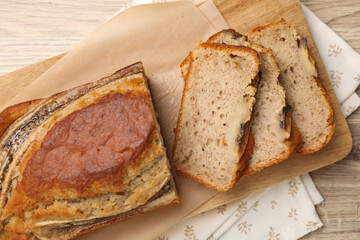 Cut banana bread on wooden table, top view