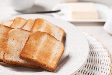 Slices of tasty toasted bread on white table, closeup
