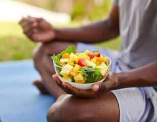 Man meditating outdoors with colorful salad in hands focus on food. Healthy eating and relaxation concept