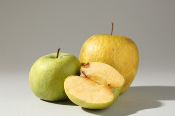 Damaged green apples on light grey background
