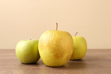 Many damaged green apples on wooden table