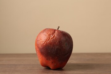 One rotten red apple on wooden table