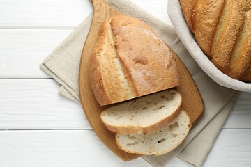 Cut bread loaf on white wooden table, flat lay. Space for text