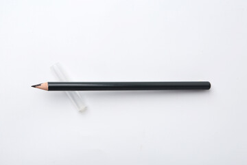 Black eyebrow pencil on white background, top view