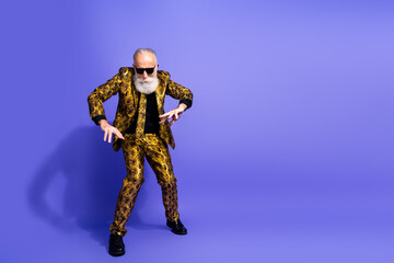 Fashionable elderly man in gold-patterned suit showcases vibrant style and charisma against a purple background