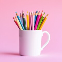 Colorful pencils in a white cup on a pink background. Art supplies for drawing, sketching, and creative projects. Workspace organization and inspiration.