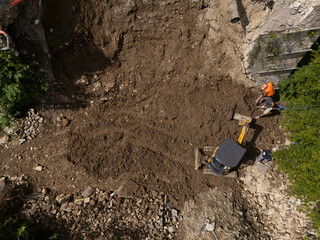 aerial view of reconstruction area with fallen wall debris after heavy rainfall showing...