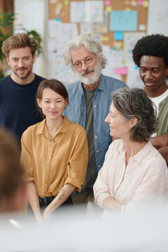 Midday in a spacious office with soft lighting A diverse group of employees from different generations is working together