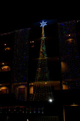 Christmas and New Year interior decoration with background, pine tree decorated with beautiful garlands of lights.