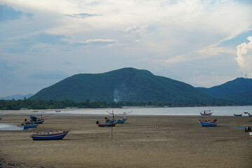 Obraz premium Landscape look view point Many fishing wooden boats on the beach at low tide at Prachuap Khiri Khan province in Thailand. Parked coast sea beach after fishing of fishermen in small village