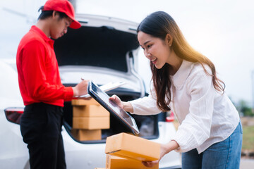 Middle-aged Asian female saleswoman delivers boxes of parcels online seller, hands packages to...