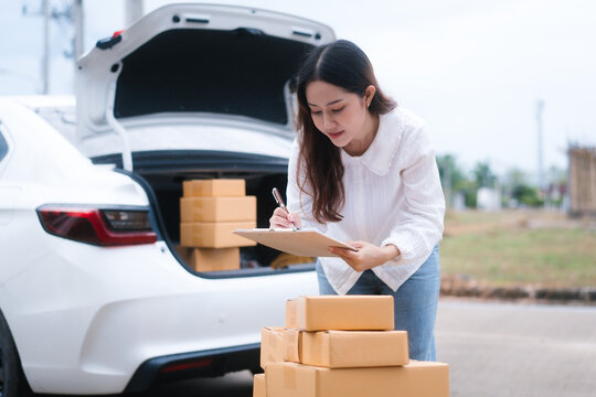 Confident middle-aged Asian woman checking the quantity of cardboard boxes before sending them to the recipient. Concept of home office, selling products online, self-delivery home delivery.