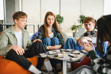 Group of young adults playing board game at home