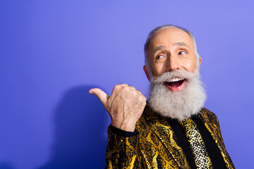Stylish senior man with white beard joyfully gesturing in vibrant attire against purple background...