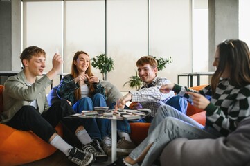 Happy friends playing board game at home