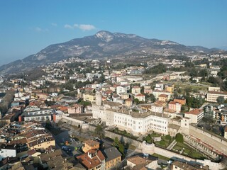 Aerial view of Trento with castle and mountains.