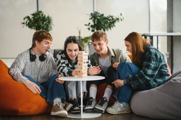 Friends playing engaging board game jenga, having fun together