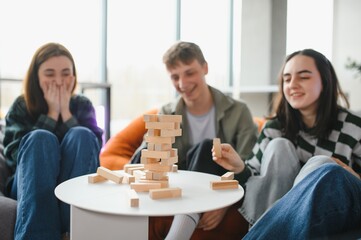 Friends playing jenga, having fun at home