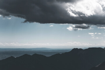 dramatic mountain landscape in a very cloudy day, with a blue sky and pastel background