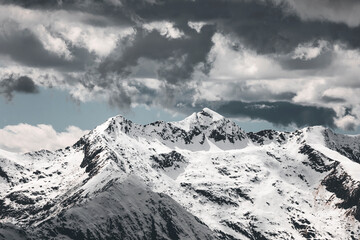 snow covered peaks and glacier in the italian alps near monte rosa in piedmont area, with cloudy and dramatic sky