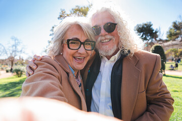 Fototapeta premium Delighted senior couple captures a memorable selfie moment filled with laughter and joy, reflecting their strong bond and affection for each other as they share a lighthearted experience together