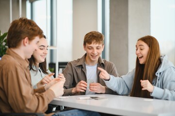 Happy students playing cards and having fun at school