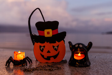 Concept: Halloween beach and ocean background with spider, witch and ghost pumpkin. Dark, scary tone.