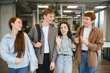 Happy students walking and talking at university