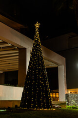 Christmas and New Year interior decoration with background, pine tree decorated with beautiful garlands of lights.