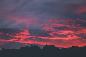 Fototapeta premium stunning and colorful sunrise over the mountains with peaks silhouettes