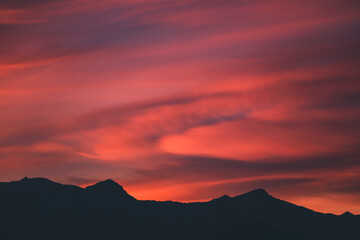 scenic and vivid sunrise over the mountains with peaks silhouettes