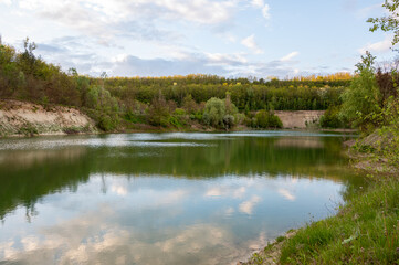An abandoned white clay quarry. A lake in the mountains