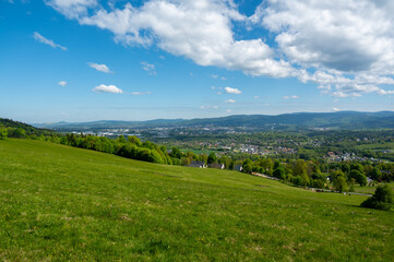 Fototapeta premium View of the city of Liberec from nearby hills around Jested mountain. Urban landscape surrounded by greenery and hills, typical northern Bohemia summer scenery