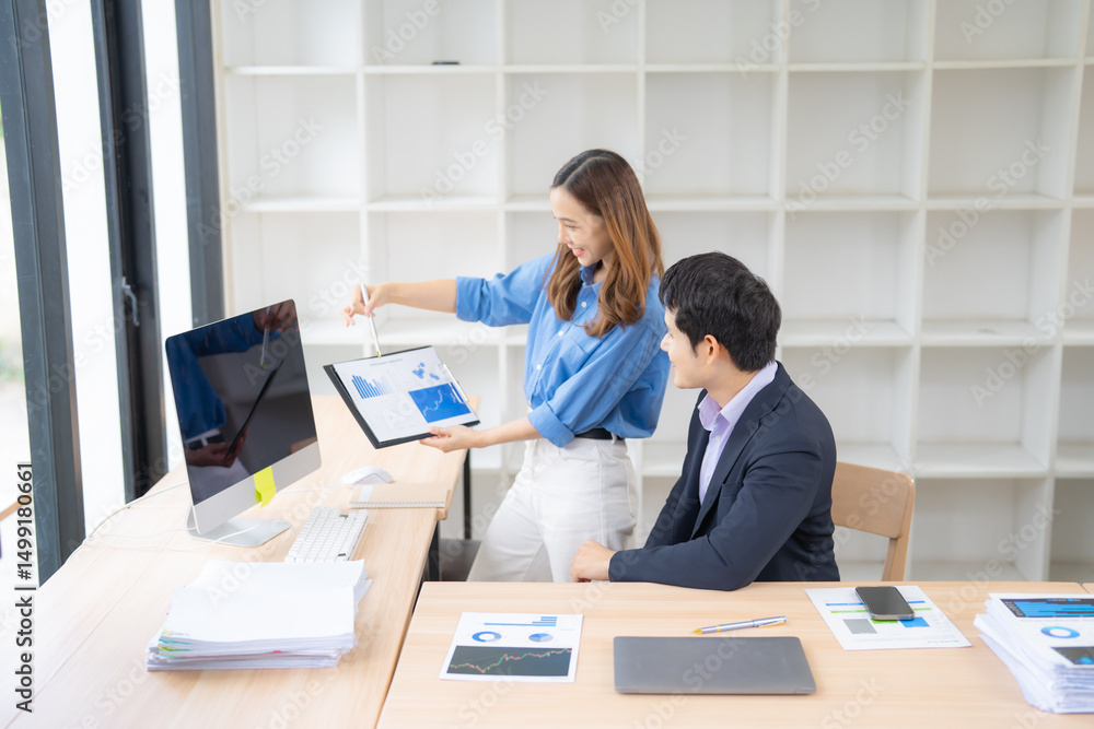 Poster two business professionals collaborate in a modern office, analyzing financial data on a digital tab