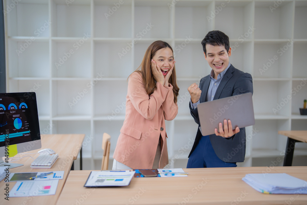 Aufkleber two business professionals express excitement while looking at a laptop in an office setting. charts