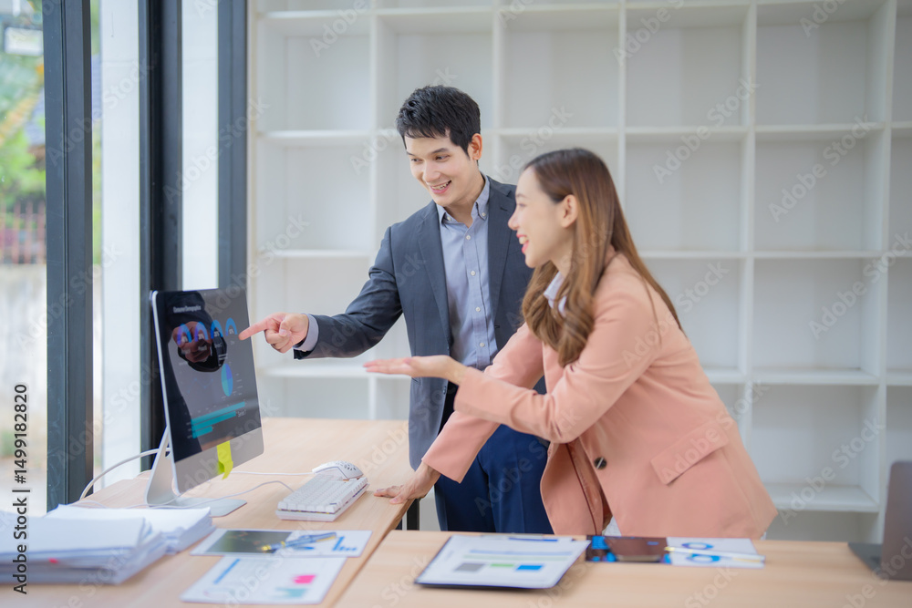 Aufkleber two asian business professionals collaborating in an office, discussing marketing data on a computer