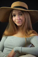 smiling and sitting comfortably in a hat