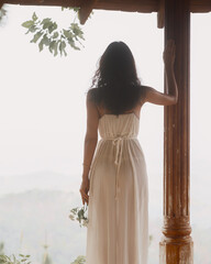 Backlit Woman in Flowing White Dress Holding Flowers by Vintage Post