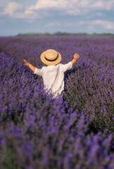 A boy in a hat runs into a field of lavender. Provence
