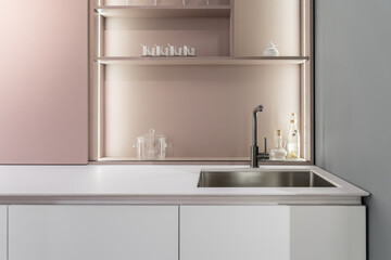 stylish modern built-in kitchen with upper and lower cabinets, drawers, shelves. kitchen facades are white and peach in color. Large, bright kitchen unit. Built-in kitchen appliances. white countertop