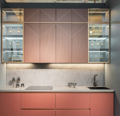 built-in peach-colored kitchen with beautiful facades. Kitchen with upper and lower cabinets,...