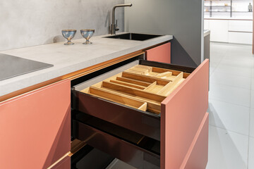 built-in peach-colored kitchen with beautiful facades. Kitchen with lower cabinets, countertop,...