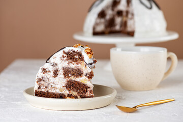 Piece of Pancho cake with pineapple and sour cream topped with chocolate and walnut on a light table. Vegan dessert. Sugar, lactose and gluten free.