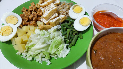 Gado-gado is a mixed vegetables salad with peanud sauce often also including boiled eggs, boiled potatoes, fried tofu  fried tempeh, and lontong