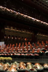 A row of candles are lit in a room with a sign that says "Please do not touch."