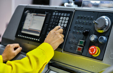 Close up Machine operator hand turns on control panel of industrial machine. technician push button on control panel