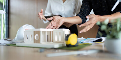 Sustainability and Engineering. Engineers collaborating on sustainable project models in a modern workspace.