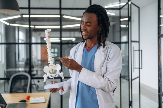 Man doctor is showing the model of human spine