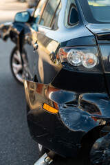 Detailed close-up of crushed automotive body panel with visible deformation, scratches, and paint damage after collision