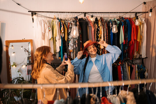 Fashionable Friends Enjoying a Stylish Photoshoot in a Vintage Clothing Store